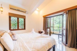 a bedroom with a bed with swans on it at Cabatales - 3BHK Villa Near Candolim Beach in Candolim +17 photos