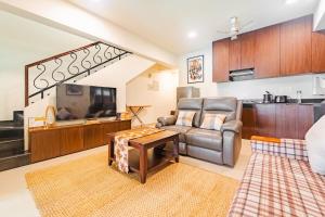 a living room with a couch and a tv at Cabatales - 3BHK Villa Near Candolim Beach in Candolim