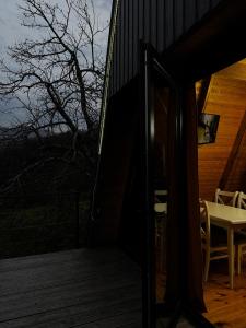une porte ouverte sur un patio avec une table sur une terrasse dans l'établissement HillSide Cottage-ჰილსაიდ კოტეჯი, à K'eda