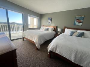 a bedroom with two beds and a large window at Amazing Lake Winni Views in Cedar Lodge Complex in Laconia +28 photos