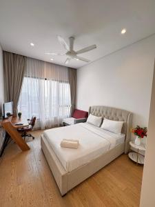 a bedroom with a large white bed and a desk at Lucentia Residence by Infinity swimming pool,lalaport KL in Kuala Lumpur