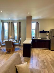 eine Küche und ein Wohnzimmer mit einer Couch und einem Tisch in der Unterkunft Hotel Villa Serena San Benito in San Salvador