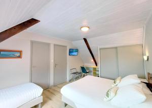 a bedroom with two beds and a desk at Chambre kerantum in Mahalon