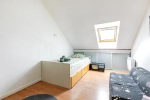 an attic room with a couch and a window at La Maison Mazarin in Chilly-Mazarin
