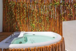 un bagno con vasca idromassaggio con parete di bambù di Casa Wayra Tulum a Tulum