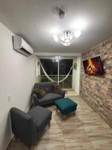 a living room with a couch and a tv at BAM - Hospedajes in Santa Marta
