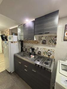 a kitchen with a stove and a refrigerator at BAM - Hospedajes in Santa Marta