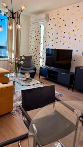 贝尔格莱德LUMIA Design Apt - Tower View - Garage Included的客厅配有电视、椅子和桌子