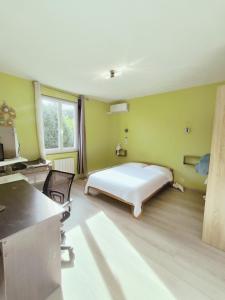 a bedroom with a bed in a room with green walls at Gîte du Vert Galant in Brantôme