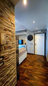 a bedroom with a bed and a stone wall at Nizzeti Home Catania Sicily Sea View in Aci Catena