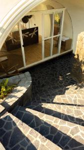 a room with a stone floor and a building with a glass door at Kisoro Art Island in Kisoro