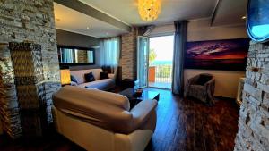 a living room with a couch and a stone wall at Nizzeti Home Catania Sicily Sea View in Aci Catena