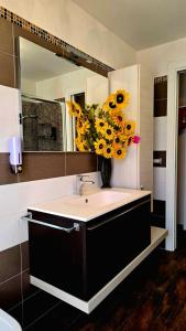 a bathroom with a sink with a vase of flowers at Nizzeti Home Catania Sicily Sea View in Aci Catena +59 photos