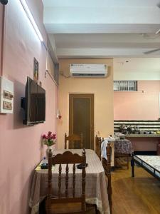 a room with a table and a tv on a wall at Sarojinilaya Homestay in Guwahati