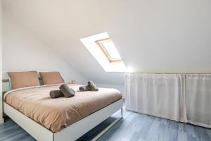 a bedroom with a bed with a skylight at La Maison Mazarin in Chilly-Mazarin