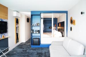 ein Wohnzimmer mit weißem Sofa und blauer Wand in der Unterkunft Hotel Atlantic in Wimereux