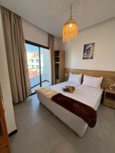 a bedroom with a large bed and a chandelier at Atlantic view Tamraght 1 in Tamraght Ou Fella