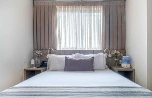 帕尔马斯Hplus Premium Palmas的一间卧室,配有一张大床和一扇窗户。