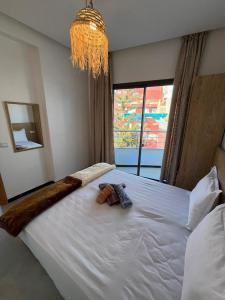 a bedroom with a large white bed with a chandelier at Atlantic view Tamraght 1 in Tamraght Oufella