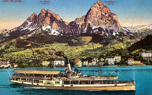 a boat in the water in front of a mountain at Erholung am Vierwaldstättersee, komfortables 3-Bett-Zimmer in Brunnen in Brunnen +4 photos