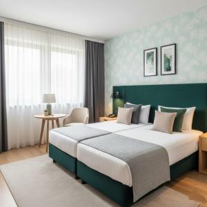 a bedroom with a large bed with a green headboard at Boulevard Side Hotel in Baku