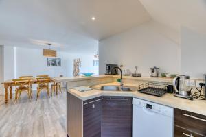 a kitchen with a sink and a table with chairs at Le Sunset Beach (les pieds dans l'eau) vue mer exceptionnelle in Fécamp +12 photos