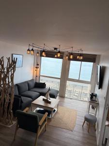 a living room with a couch and a table at Gîte Les pieds dans l eau à Fécamp avec pleine vue mer in Fécamp