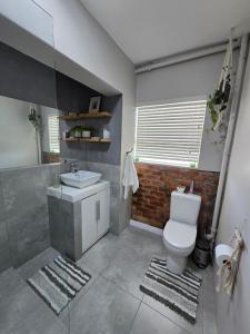 a bathroom with a white toilet and a sink at Panorama Sea and Mountain Views in Strand +36 photos