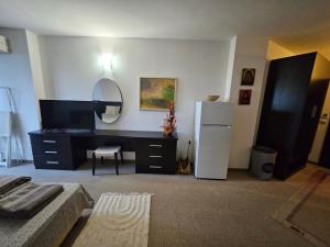 a living room with a refrigerator and a mirror at Студио за двама в Сарафово in Burgas City