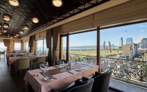 a restaurant with tables and chairs and a large window at Boulevard Side Hotel in Baku