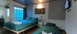 a bedroom with two beds and a television in it at อู่ตะเภาโฮมสเตย์byต้นไทร in Ban Nong Sa +32 photos