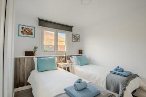 two beds in a room with blue towels on them at Villa Katya by Villalize in Teguise