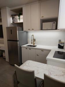 a kitchen with a table and a sink and a refrigerator at Loft av central in Xangri-lá