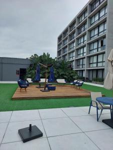 a courtyard with chairs and umbrellas in front of a building at Loft av central in Xangri-lá