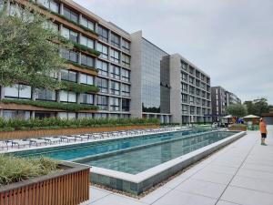 a swimming pool in front of a building at Loft av central in Xangri-lá