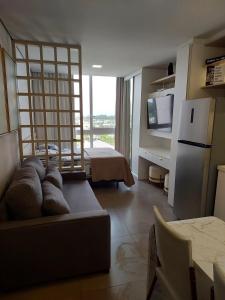 a living room with a couch and a tv and a kitchen at Loft av central in Xangri-lá