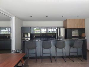 a kitchen with a bar with stools in it at Loft av central in Xangri-lá