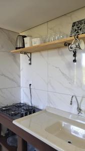 a kitchen counter with a sink and a stove at Garagem 36 próximo a Serra do Rio do Rastro in Louro Müller