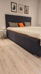 Una cama grande en un dormitorio con suelo de madera. en Apartmán Horný Smokovec, en Starý Smokovec