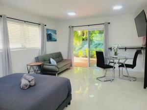 ein Schlafzimmer mit einem Bett, einer Couch und einem Tisch in der Unterkunft Kevin#B Chic Studio with Patio near Fort Lauderdale Beach in Fort Lauderdale