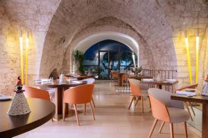 a restaurant with tables and chairs and a stone wall at La Sommità Relais & Chateaux in Ostuni