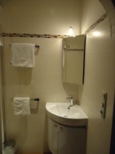 a bathroom with a sink and a mirror and towels at Pension Wald in Faistenau