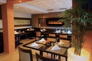 a restaurant with tables and chairs and a fireplace at Römerhof in Stuttgart
