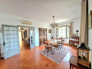 sala de estar con mesa, sillas y piano en BASTIDE PRESQU ILE DE GIENS SUPERBE VUE MER PISCINE, en Hyères