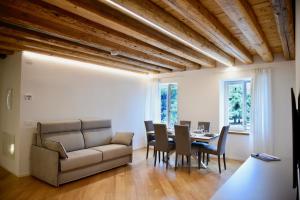 a living room with a couch and a table and chairs at Udine Urban Nest in Udine