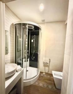 a bathroom with a large shower and a sink at Briiz Hotel Baku in Baku