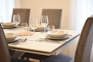 a table with wine glasses and plates on it at Udine Urban Nest in Udine