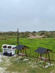 zwei Picknicktische und ein Boot auf einem Feld in der Unterkunft La Solidea Complejo de Mar in San Clemente del Tuyú + 28 Fotos