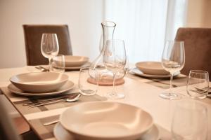 a table with plates and wine glasses on it at Udine Urban Nest in Udine +25 photos