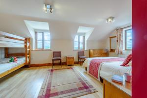 a bedroom with two beds and two chairs at Beudy Bach in Silian